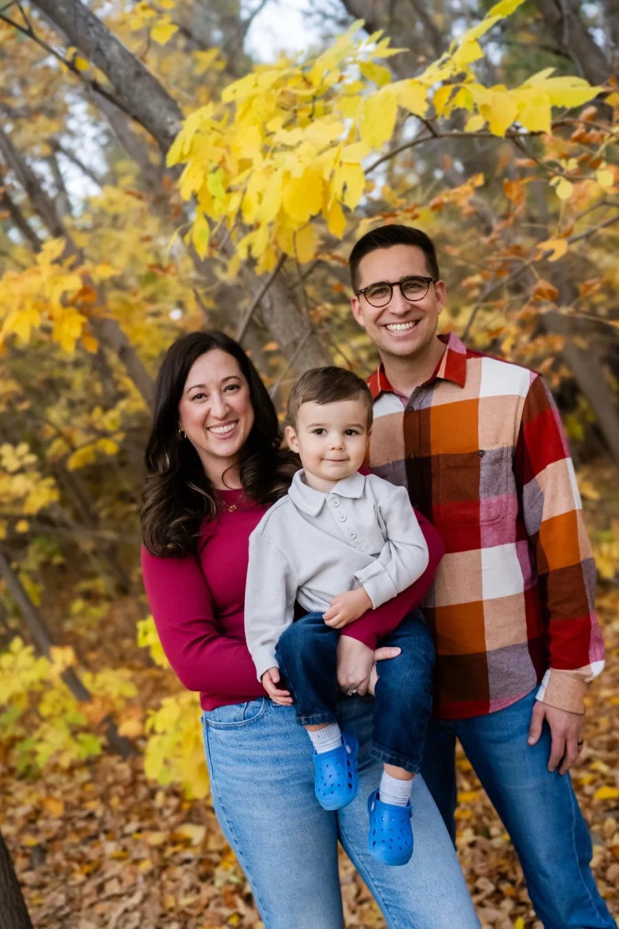 Our family together beneath golden autumn leaves.